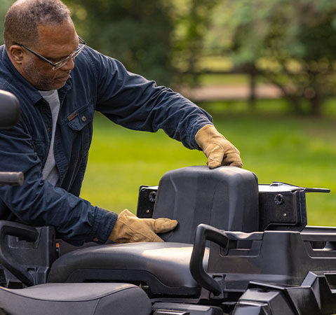 Person putting up the industry-exclusive convertible rear seat for a passenger on the 2026 Polaris Sportsman X2 570 ATV.