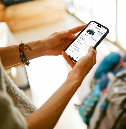 A person using the RIDE COMMAND app on their smartphone to track vehicle data.