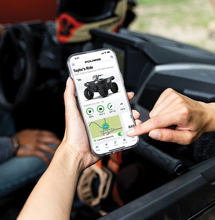A person using RIDE COMMAND+ on their smartphone to track vehicle data.
