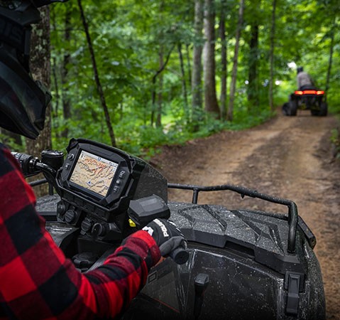 A rider on a Polaris Sportsman ATV using the Group Ride feature on the RIDE COMMAND touch screen display.