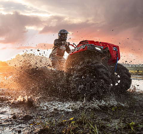 A rider on a 2027 Polaris Sportsman Mud Edition ATV in a deep mud hole showcasing the handlebar grab hoop.