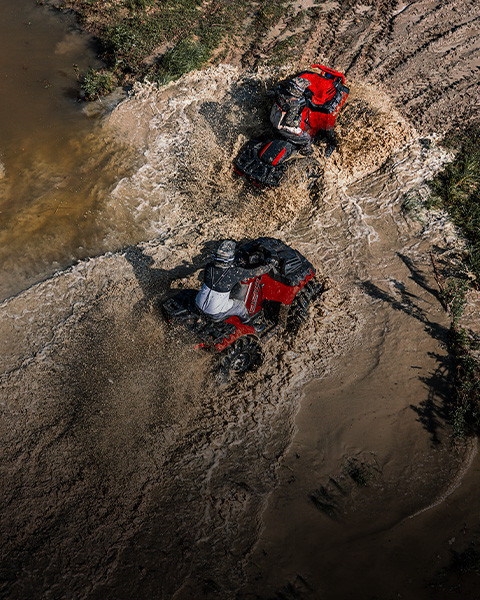 Un resistente ATV Polaris Sportsman Mud Edition se enfrenta a un terreno lleno de lodo con llantas enérgicas y una gran altura desde el suelo.