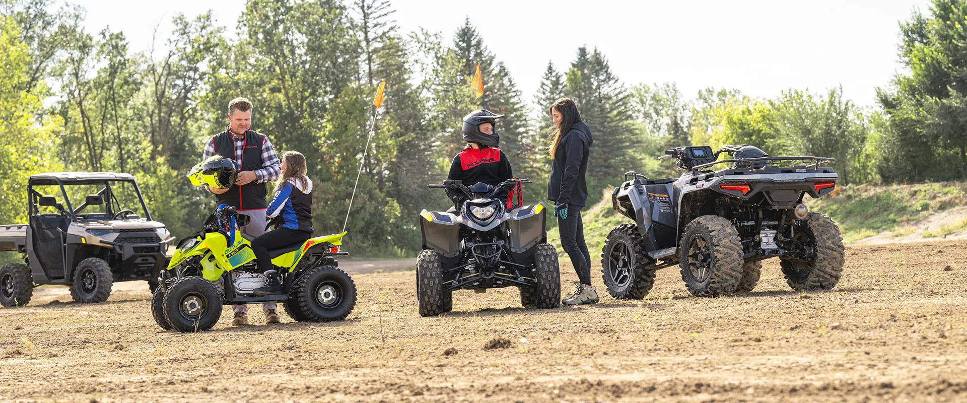 2 kids on their Polaris youth ATVs getting ready for a ride.
