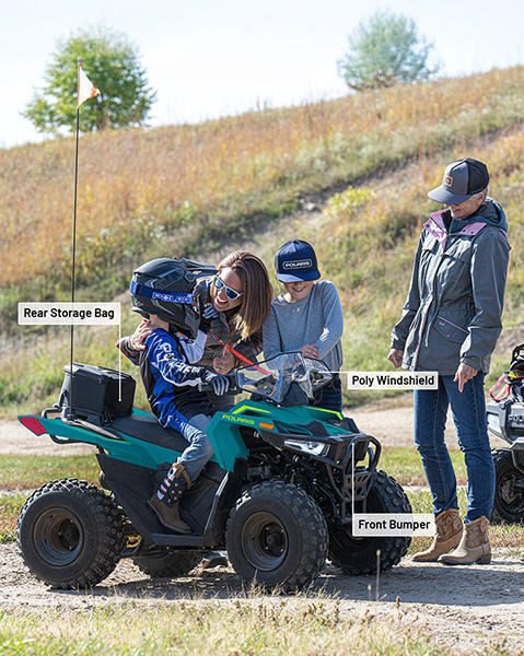 Rear Storage Bag, Poly Windshield, and Front Bumper accessories installed on a 2026 Polaris Outlaw 70 EFI youth ATV.