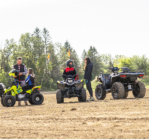 A child on a 2027 Polaris Phoenix 200 youth ATV talking to their parent.
