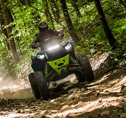A rider on a 2027 Polaris Scrambler XP 1000 S sport ATV with illuminated headlights.
