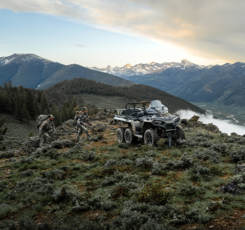 2 hunters walking toward a 2027 Polaris Sportsman 6x6 600 2-up ATV.