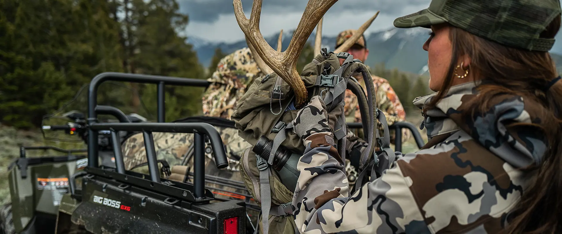 A female hunter gearing up with cargo from the box of her 2027 Polaris Sportsman 6x6 600 2-up ATV.