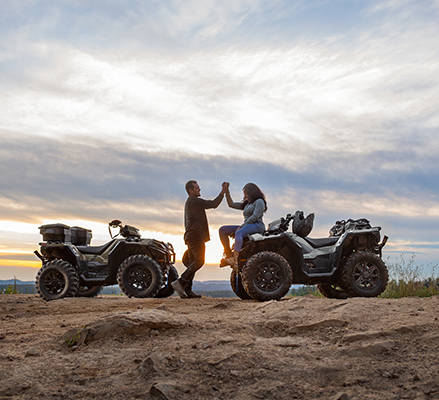 2 people clasping hands after enjoying a ride on their 2027 Polaris Sportsman 850 ATVs.