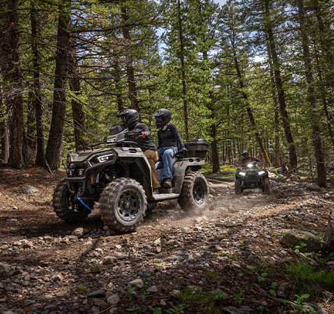 2 riders cruising through the forest on their 2027 Polaris Sportsman Touring 600 2-up ATV.