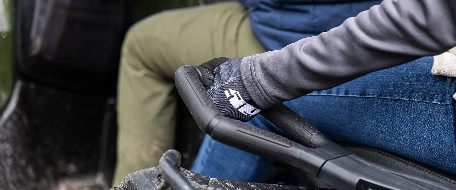 A person holding onto a handle on a 2027 Polaris Sportsman Touring 600 2-up ATV.