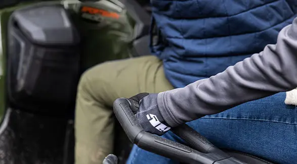 A person holding onto a handle on a 2027 Polaris Sportsman Touring 600 2-up ATV.