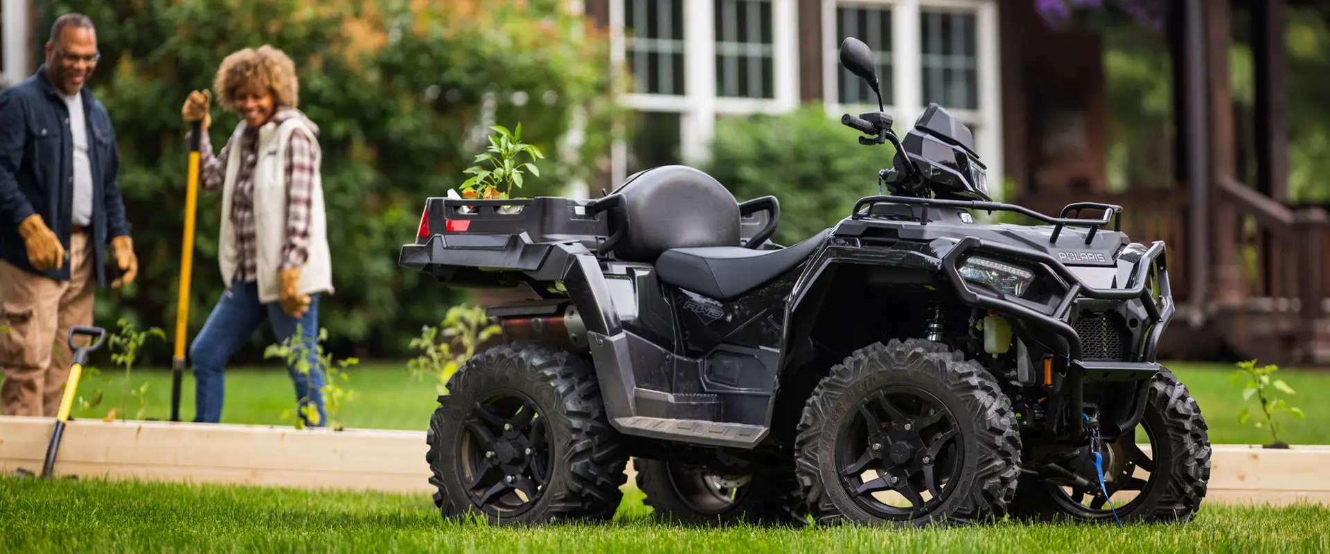 A couple building a garden near their 2027 Polaris Sportsman X2 600 2-up ATV.