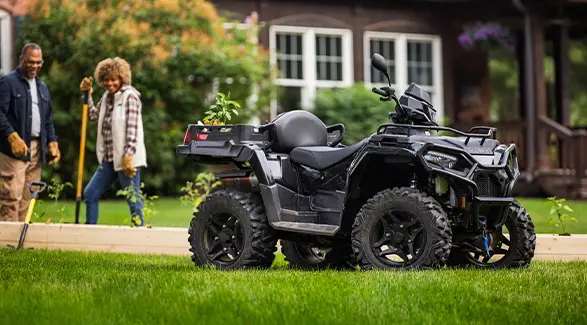 A couple building a garden near their 2027 Polaris Sportsman X2 600 2-up ATV.