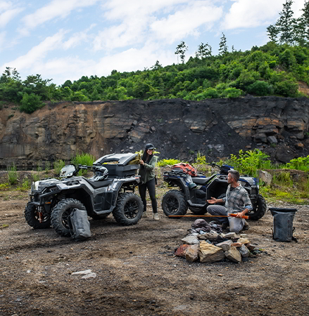 People building a fire with items they brought in the cargo storage on their 2027 Polaris Sportsman XP 1000 ATV.