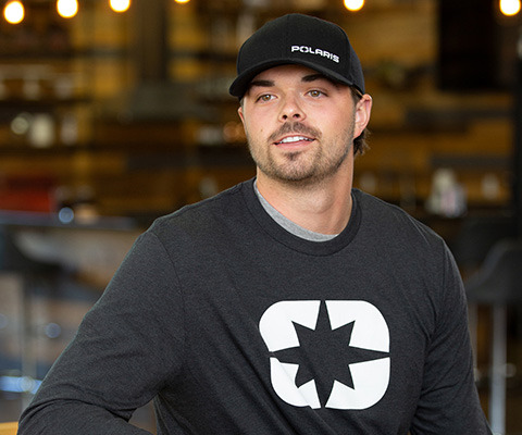 closeup of a man wearing a polaris hat and t-shirt