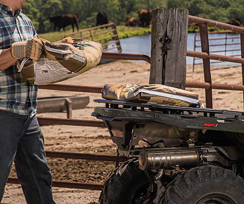 A man loading a soil sack to the racks of his Sportsman