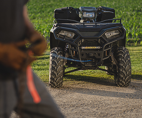 A man pulling the winch from the front of his sportsman