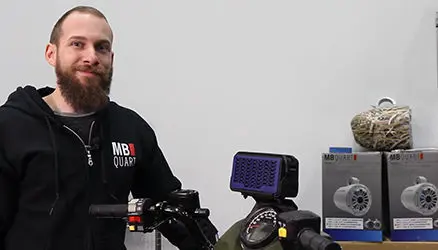 Instructeur avec un veston noir qui installe un haut-parleur Bluetooth étanche