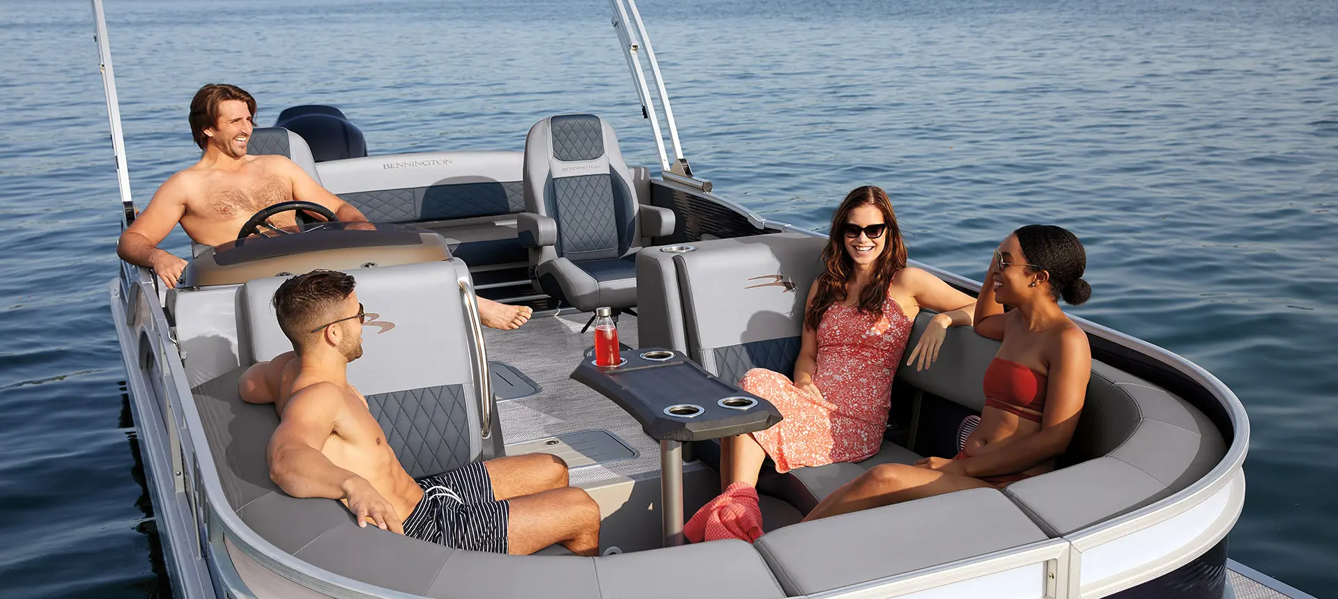Four people having a laugh while seated inside of a L Bowrider pontoon