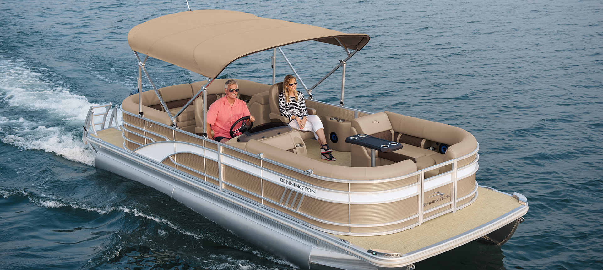 Two people on a Bennington L boat cruising through the water