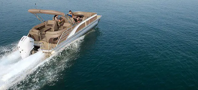 rear view of a bennington l bowrider pontoon boat cruising across a lake