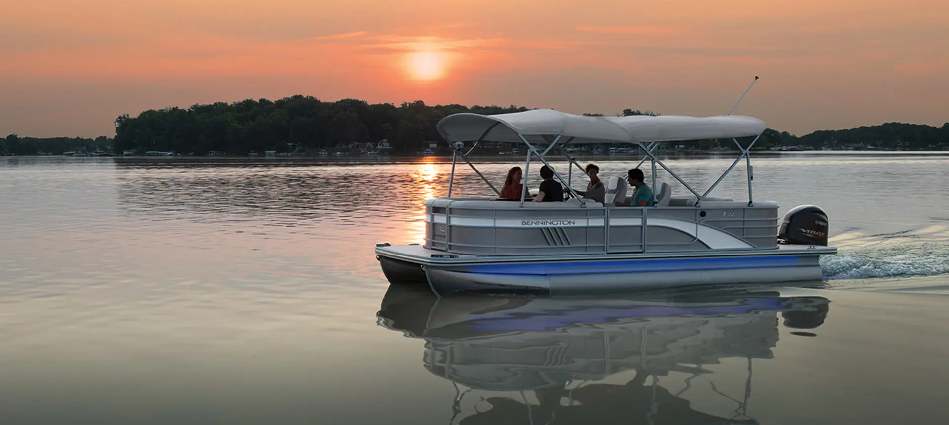 bennington l pontoon boat floating along at sunset