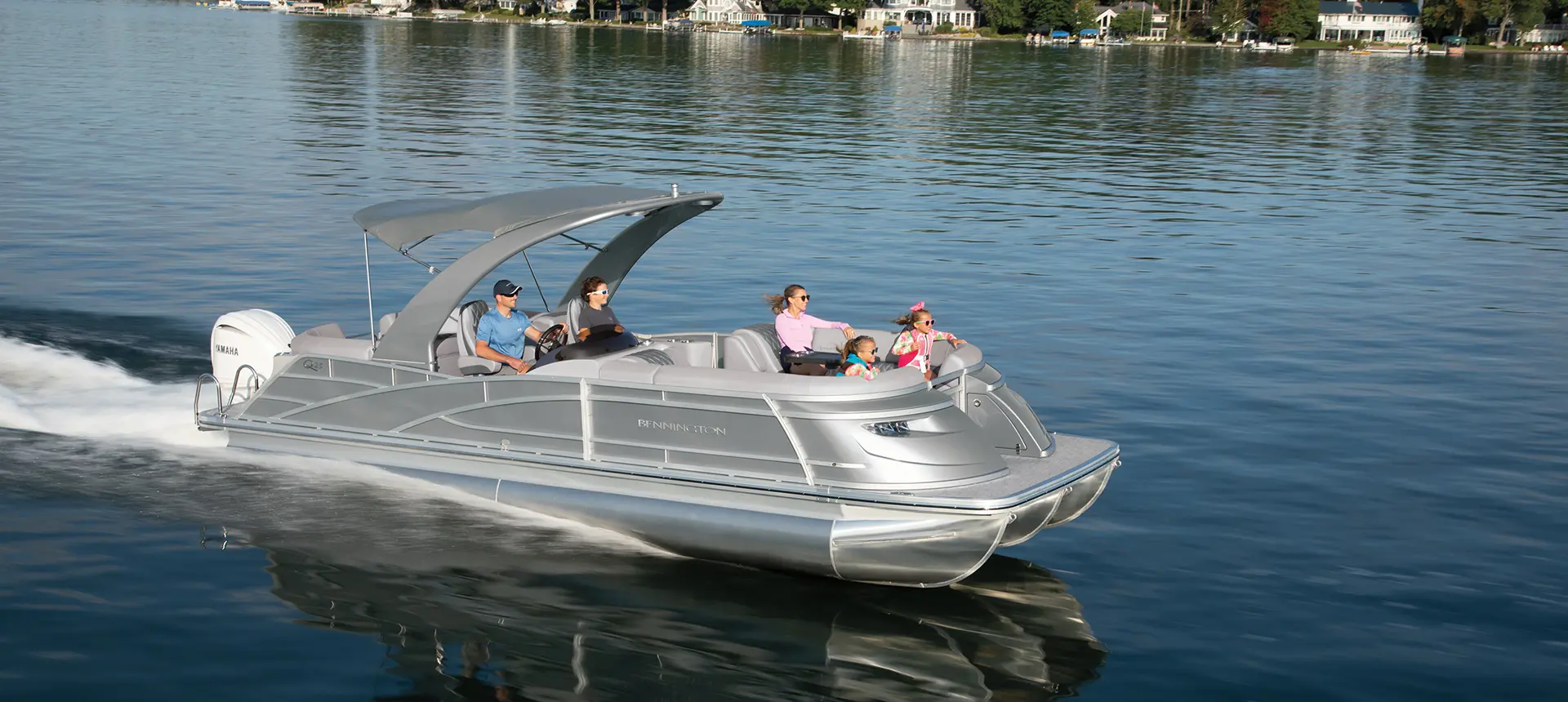 a Bennington Q Pontoon Boat speeding across a lake