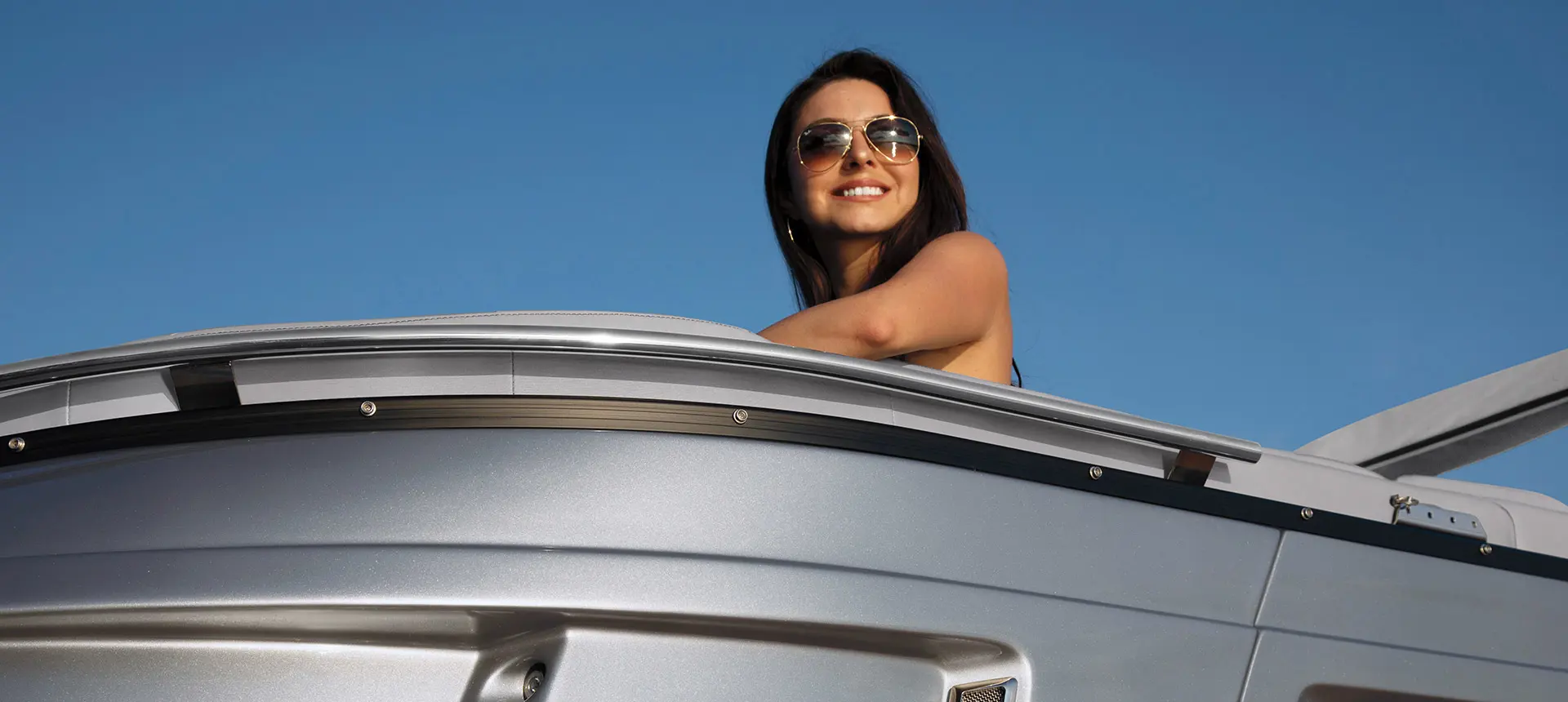 A woman smiling while chilling on a Bennington QX pontoon