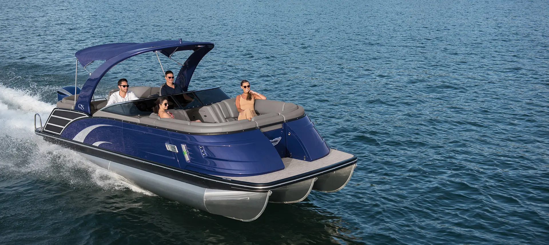 blue Bennington QX pontoon cruising across a lake