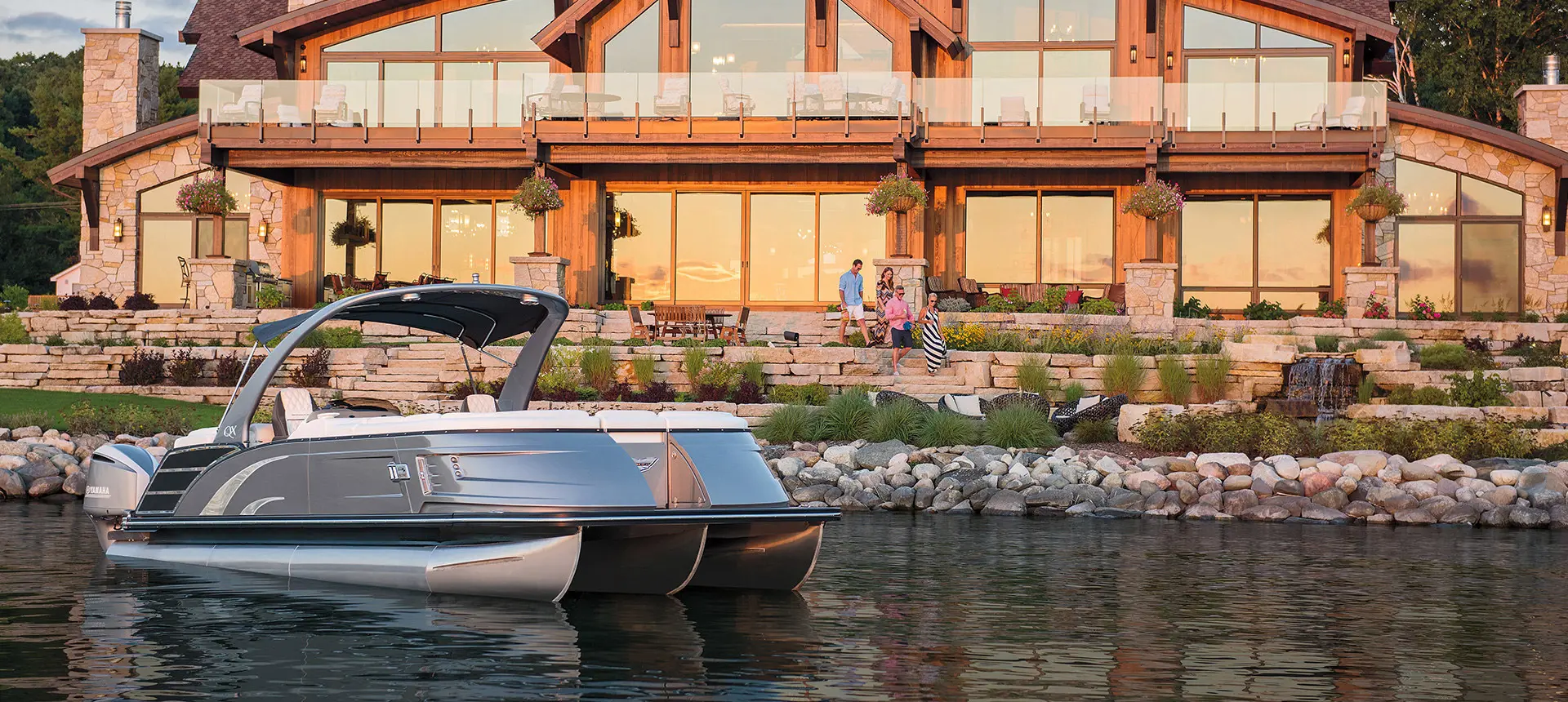 Bennington QX pontoon floating near a lake home