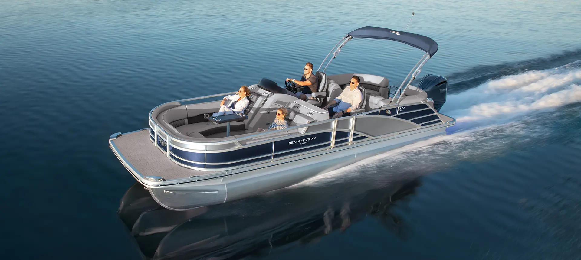 aerial view of a bennington r bowrider pontoon boat cruising on a lake