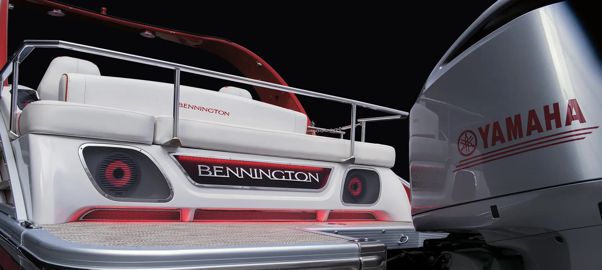 bennington branding and integrated speakers on the stern of a bennington r bowrider pontoon boat with swingback floor plan