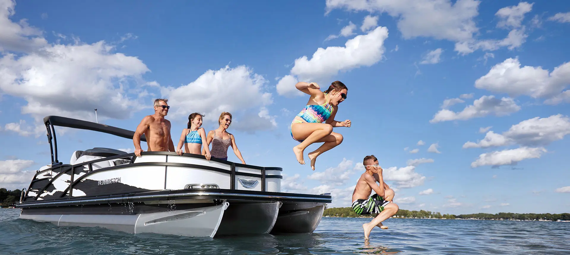 two kids jumping off the bow of a Bennington R Bowrider Pontoon Boat