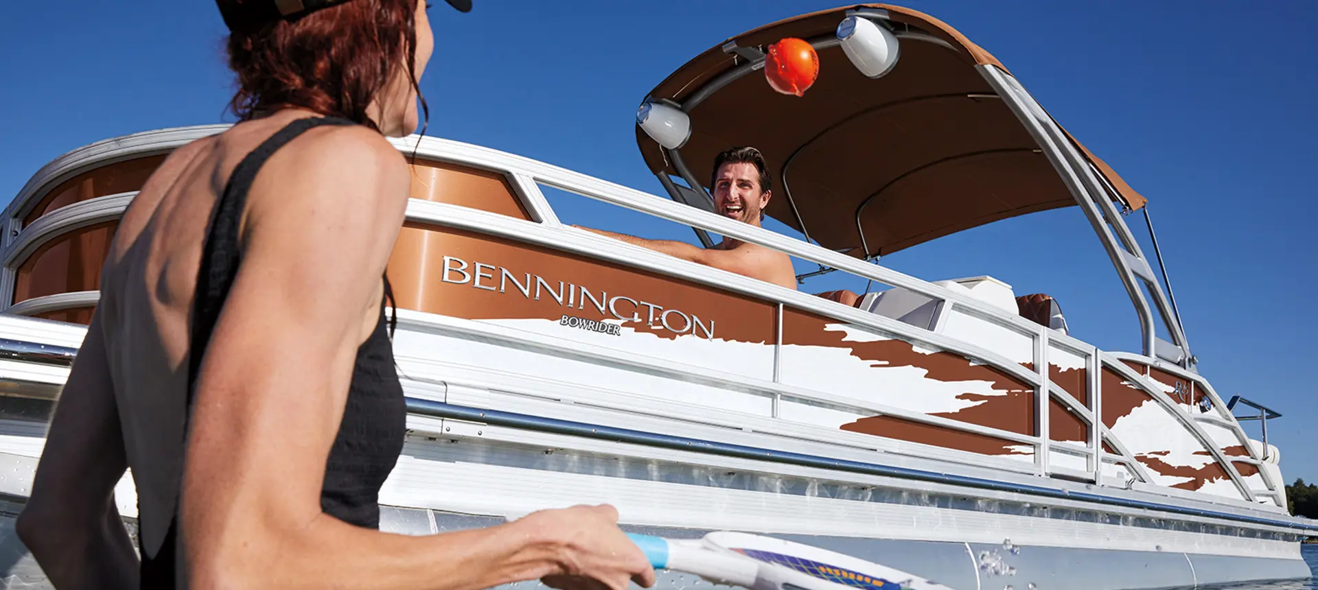man smiling at a woman on a bennington r bowrider pontoon boat