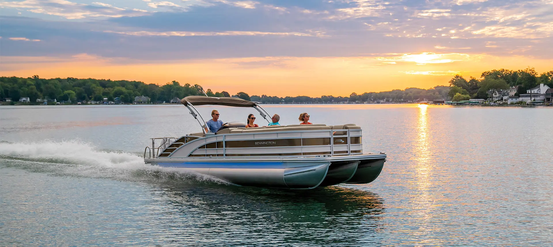 side view of a Bennington R pontoon speeding across a lake