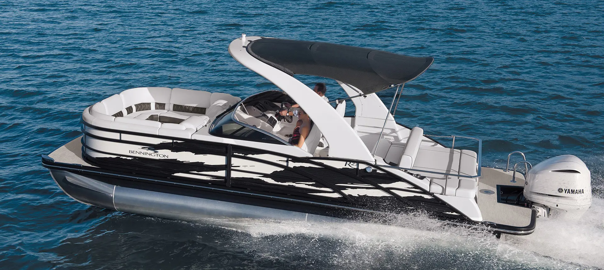 side view of a Bennington R pontoon speeding across a lake
