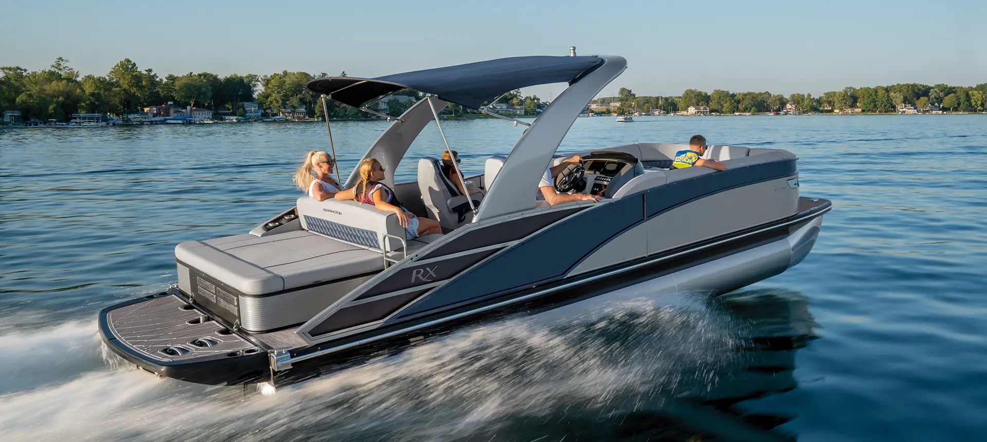 side profile of a bennington rx sport pontoon boat cruising on a lake