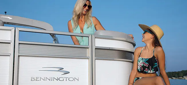 Two women seated on a Bennington S pontoon boat