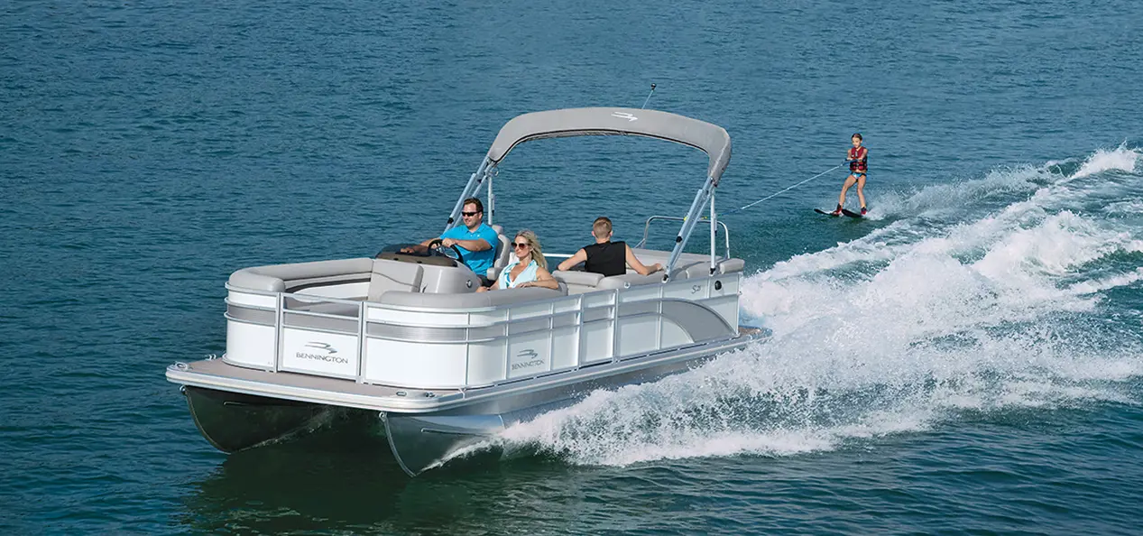 person wake boarding behind a Bennington S pontoon boat on a lake