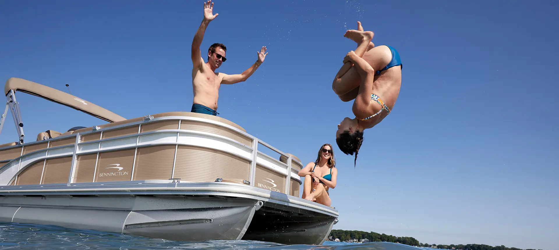 girl flipping off the bow of a Bennington S pontoon boat into the water