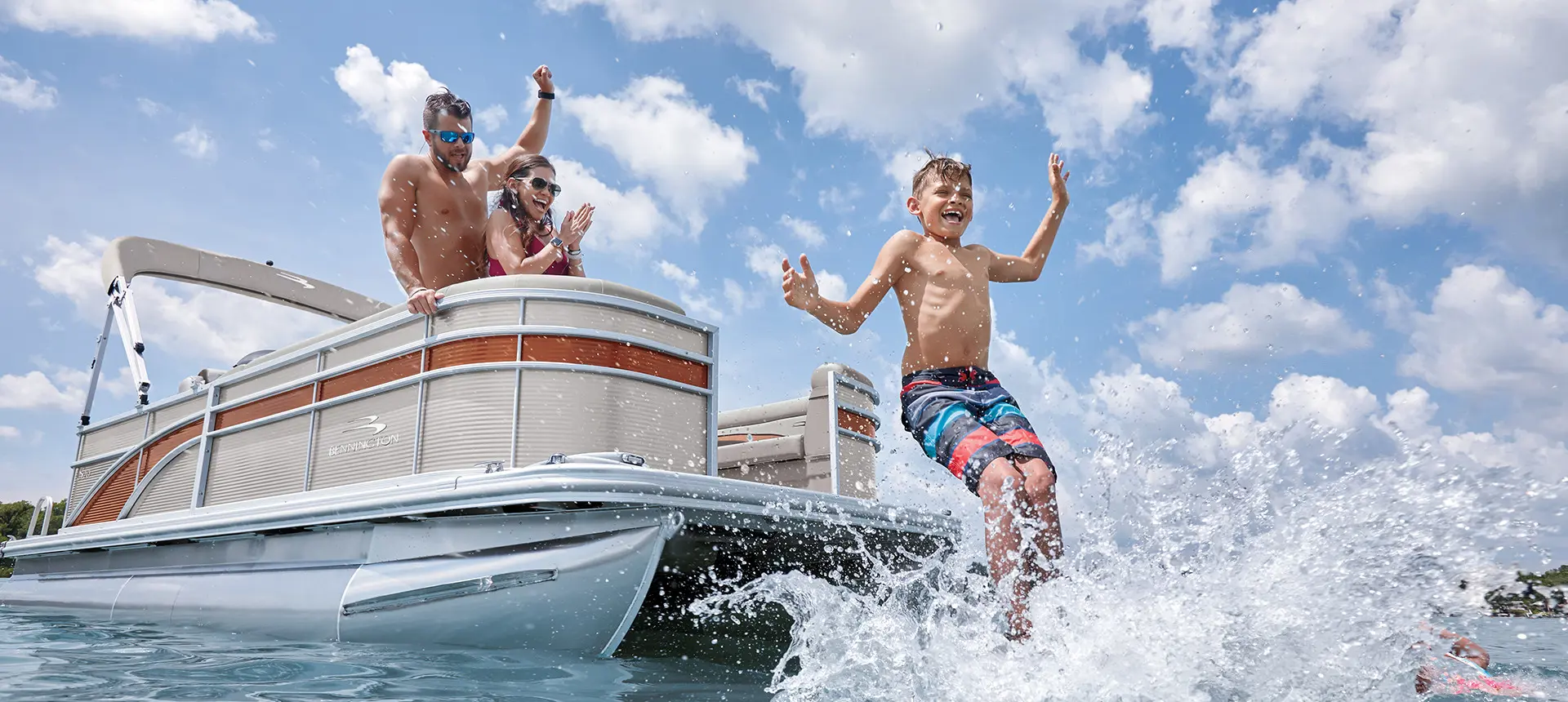 boy jumping into the water from a Bennington S pontoon boat