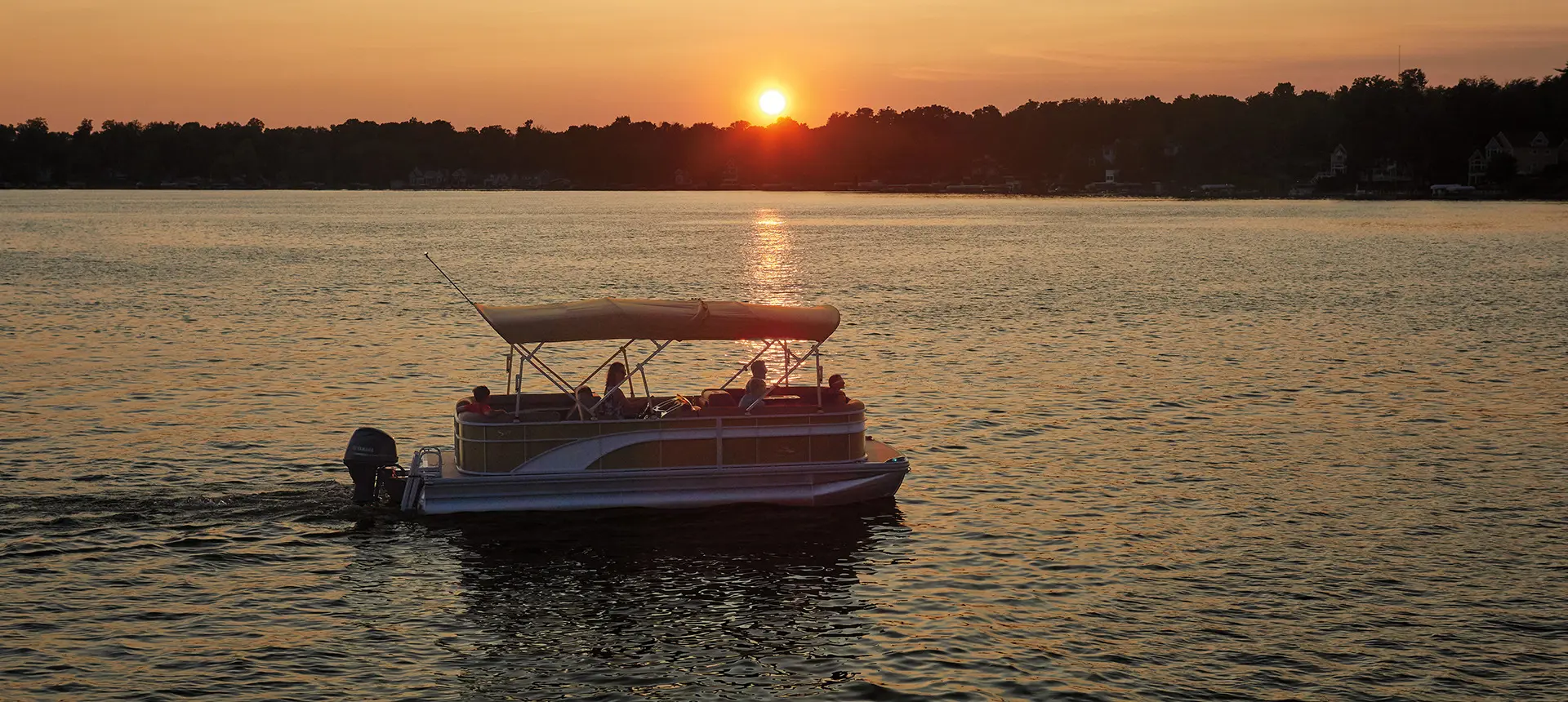 Bennington S pontoon boat cruising at sunset
