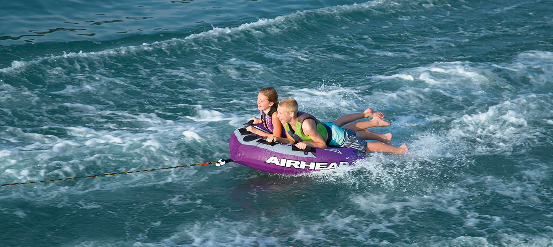 kids tubing behind a Bennington SV pontoon boat