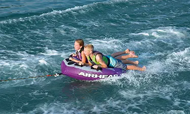 kids tubing behind a Bennington SV pontoon boat