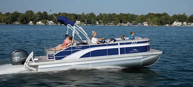 side view of a Bennington SX pontoon boat cruising across a lake
