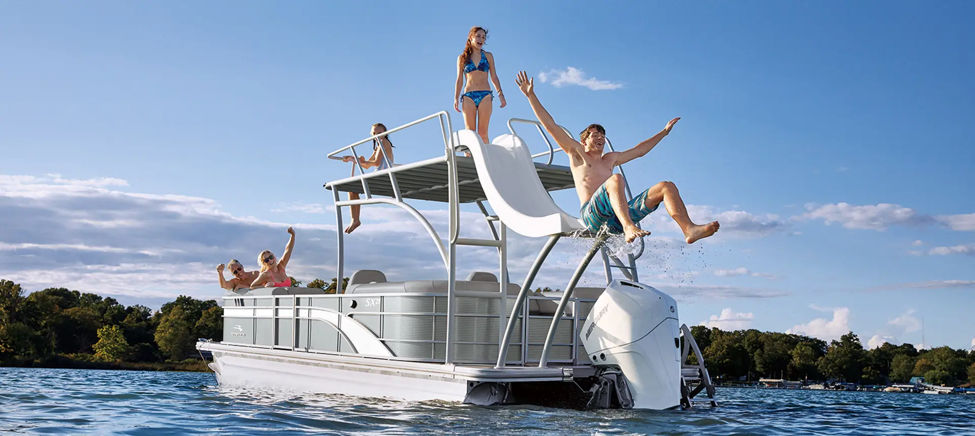 man using the slide on a bennington sx pontoon boat