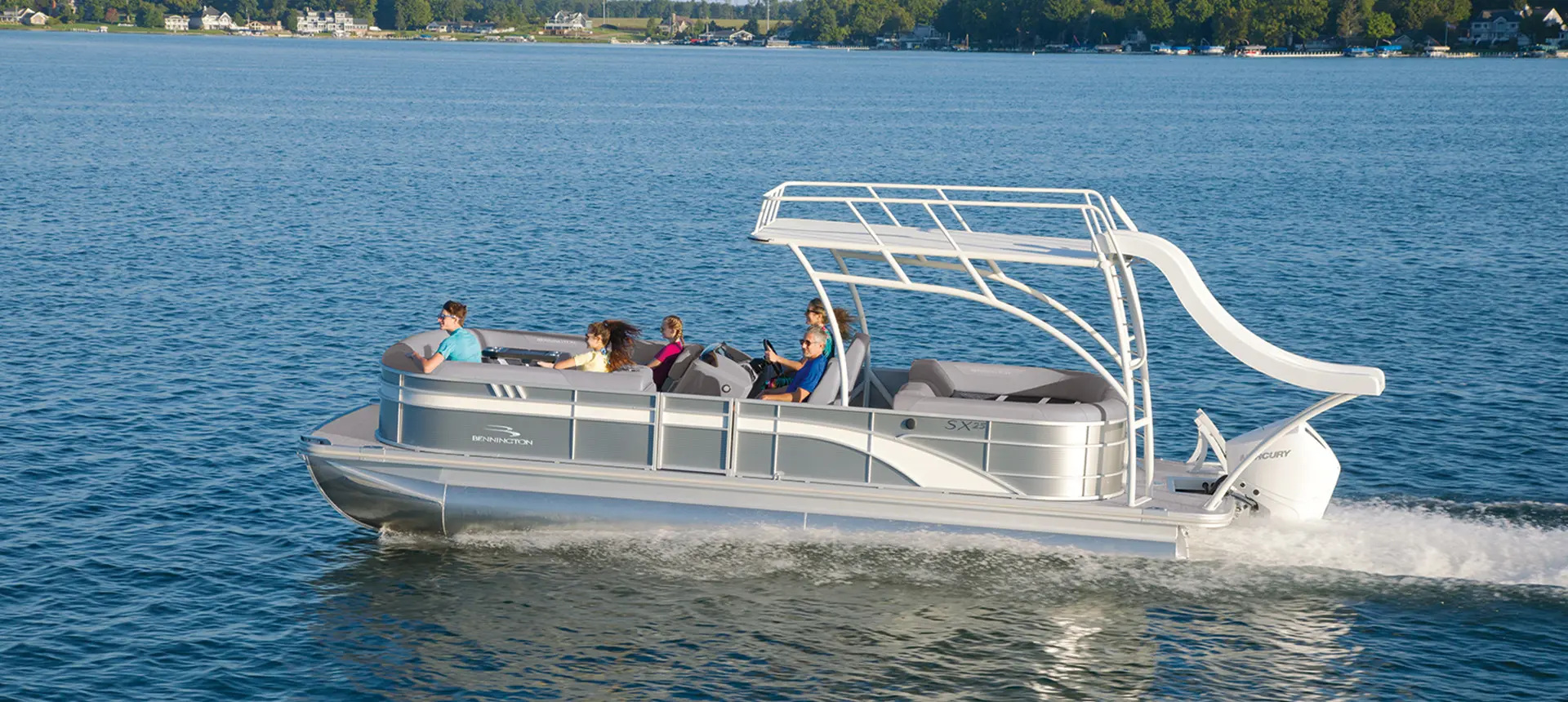 Side view of a Bennington SX pontoon boat on a lake