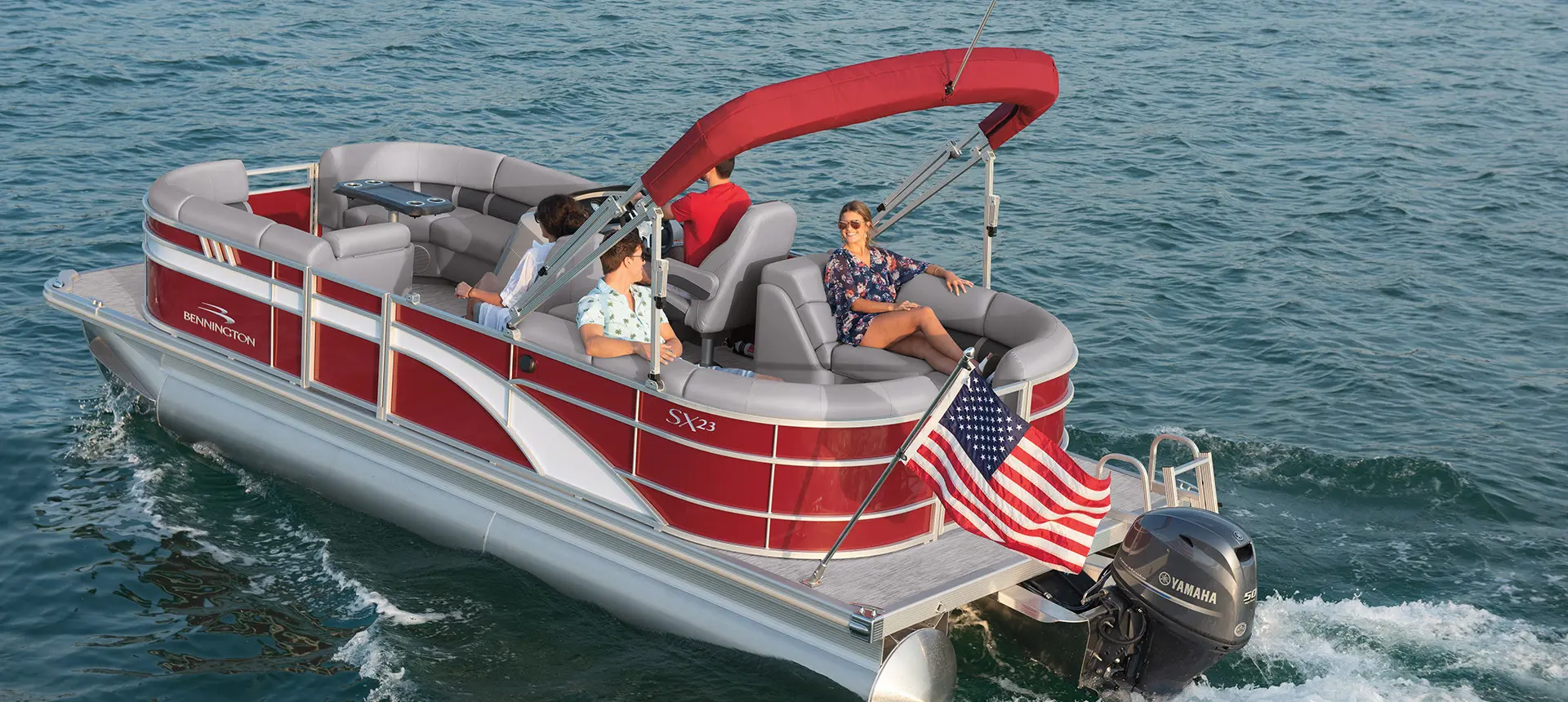 Rear view of a Bennington SX pontoon boat cruising on a lake