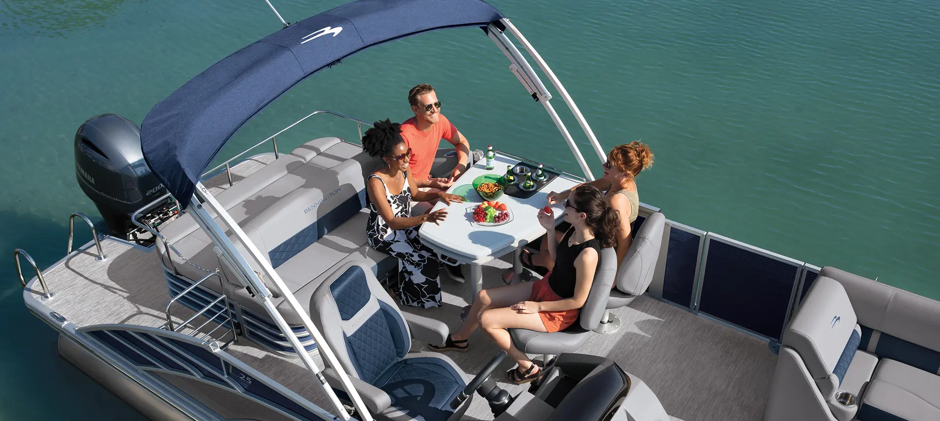aerial view of people eating at the stern table on a bennington l pontoon boat with swingback floor plan